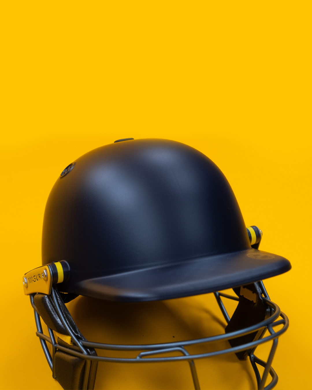 Masuri E Line Player Steel navy cricket batting helmet, three-quarter front view showing the peak and steel Eye-Line grille